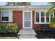 Close-up of a red brick house with a decorative front door and well-maintained garden at 1301 Cambridge Dr, Leesburg, FL 34748