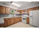 Functional kitchen featuring wooden cabinetry, modern appliances, and tile flooring at 1301 Cambridge Dr, Leesburg, FL 34748