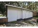 Outdoor storage shed with white siding and three white doors at 1301 Cambridge Dr, Leesburg, FL 34748