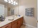 Bathroom featuring wooden cabinets, a vanity, large mirror, and neutral color scheme at 1351 Legendary Blvd, Clermont, FL 34711
