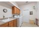 Well-lit laundry room with a sink, modern washer and dryer, wooden cabinets, and white walls at 1351 Legendary Blvd, Clermont, FL 34711