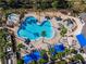 Aerial view of a large community pool with ample lounge chairs and palm trees, perfect for relaxation at 1351 Legendary Blvd, Clermont, FL 34711