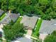 Aerial view of a well-manicured property featuring lush landscaping, a paved driveway, and a neatly kept lawn at 1556 Blue Grass Blvd, Deland, FL 32724