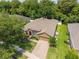 Aerial view of a well-maintained home with a lush lawn, driveway, and mature trees at 1556 Blue Grass Blvd, Deland, FL 32724