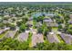 Scenic aerial view of a residential neighborhood with single-Gathering homes surrounding a picturesque lake and lush greenery at 1556 Blue Grass Blvd, Deland, FL 32724