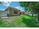 Image showcasing the grassy backyard with white fence and side view of home's exterior at 1556 Blue Grass Blvd, Deland, FL 32724