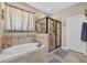 Bathroom features a soaking tub with a glass shower and tile flooring at 1556 Blue Grass Blvd, Deland, FL 32724