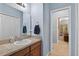 Neutral-toned bathroom features modern vanity, large mirror, and convenient access to living space at 1556 Blue Grass Blvd, Deland, FL 32724