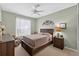 Light-filled bedroom features a queen bed, dresser, nightstand and calming neutral color palette at 1556 Blue Grass Blvd, Deland, FL 32724