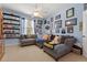 Cozy bedroom with comfortable gray couches, ceiling fan, and shelf for displaying collectibles at 1556 Blue Grass Blvd, Deland, FL 32724