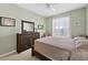 Well-lit bedroom featuring wood dresser, large mirror, neutral colors, and a bright, airy feel at 1556 Blue Grass Blvd, Deland, FL 32724