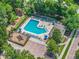 Aerial view of the community pool with lounge chairs, playground, parking lot, and lush green landscaping at 1556 Blue Grass Blvd, Deland, FL 32724