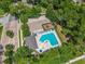 Aerial view of the community pool, playground, and parking lot, all surrounded by lush greenery at 1556 Blue Grass Blvd, Deland, FL 32724