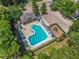 Aerial view of the community pool with plenty of lounge chairs, a gazebo, a playground, and a parking lot at 1556 Blue Grass Blvd, Deland, FL 32724