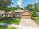 Charming single-story home with well-manicured lawn, stone accents, and a brick driveway at 1556 Blue Grass Blvd, Deland, FL 32724