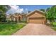 Attractive single-story home with brick driveway, well-maintained lawn, and stone accents on the facade at 1556 Blue Grass Blvd, Deland, FL 32724