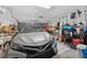 Garage interior featuring a modern silver car parked alongside storage shelves and various household items at 1556 Blue Grass Blvd, Deland, FL 32724