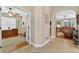 Hallway with hardwood floors and an open doorway to an office with a ceiling fan at 1556 Blue Grass Blvd, Deland, FL 32724