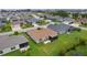 Aerial view of the property highlighting the home, screened lanai, and lush landscaping at 1721 Germakian Ln, The Villages, FL 32163
