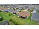 Aerial view of the backyard, screened in patio, manicured lawn, and well-maintained landscaping at 1721 Germakian Ln, The Villages, FL 32163