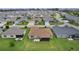 An aerial view of the property showcasing the home, backyard with screened lanai, and landscaped lawn at 1721 Germakian Ln, The Villages, FL 32163