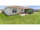 Backyard area featuring a small patio with table and chairs and a view of the screened lanai at 1721 Germakian Ln, The Villages, FL 32163