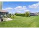 Spacious backyard with a screened lanai, green lawn, and neatly trimmed hedges at 1721 Germakian Ln, The Villages, FL 32163