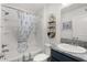 Charming bathroom with a tub and shower, lovely shower curtain, modern sink, and decorative shelving at 1721 Germakian Ln, The Villages, FL 32163