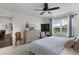 Inviting bedroom featuring a dresser, soft blue bedding, and a view of the outdoors at 1721 Germakian Ln, The Villages, FL 32163