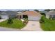 Beautiful home showcasing lush landscaping, a two-car garage, and a welcoming facade at 1721 Germakian Ln, The Villages, FL 32163