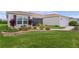 Well-maintained front lawn with flower beds, showcasing the home's charming exterior at 1721 Germakian Ln, The Villages, FL 32163