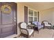 Inviting front porch with wicker furniture and a decorative wreath on the front door at 1721 Germakian Ln, The Villages, FL 32163