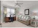 Bright office space with a comfortable sofa, desk, chair, decorative lamps, and large window at 1721 Germakian Ln, The Villages, FL 32163