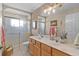 Bathroom featuring double sinks, decorative lights, and a tiled shower at 17355 Se 110Th Ter, Summerfield, FL 34491