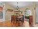 Charming dining room with a view outside, hardwood floors, and a decorative light fixture, perfect for Gathering meals at 17355 Se 110Th Ter, Summerfield, FL 34491