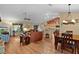Open-concept living room featuring hardwood floors, a comfortable sofa, and a seamless transition to the dining and kitchen areas at 17355 Se 110Th Ter, Summerfield, FL 34491
