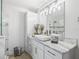Bright bathroom featuring marble countertops, white cabinets, stylish lighting, and a glass-enclosed shower at 17824 Se 87Th Bourne Ave, The Villages, FL 32162
