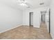 Simple bedroom with tile floors, ceiling fan, and standard closet with slider doors at 17824 Se 87Th Bourne Ave, The Villages, FL 32162