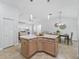 A kitchen island with a light countertop and wooden cabinets overlooks the living area in this open-concept home at 17824 Se 87Th Bourne Ave, The Villages, FL 32162