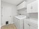 Well-lit laundry room with washer, dryer, utility sink, and ample storage cabinets at 17824 Se 87Th Bourne Ave, The Villages, FL 32162