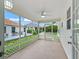 Covered screened porch overlooking a fenced backyard and landscape, with a ceiling fan and lighting at 17824 Se 87Th Bourne Ave, The Villages, FL 32162