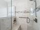 Tiled shower with glass door, a built-in bench, niche, and a grab bar for accessibility at 17824 Se 87Th Bourne Ave, The Villages, FL 32162