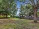 Large backyard space with mature trees and a wooden fence creating a private outdoor retreat at 2019 Newtown Rd, Groveland, FL 34736