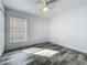 Bright bedroom features wood look tile, a ceiling fan, and a window at 2019 Newtown Rd, Groveland, FL 34736