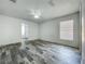 Spacious bedroom with modern gray wood-look flooring, a bright window and neutral walls for a calming atmosphere at 2019 Newtown Rd, Groveland, FL 34736