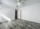 Bright bedroom featuring stylish gray wood-look flooring, a ceiling fan, and a closet for ample storage at 2019 Newtown Rd, Groveland, FL 34736