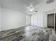 Inviting bedroom with gray wood-look flooring, featuring a ceiling fan and ample natural light, perfect for relaxation at 2019 Newtown Rd, Groveland, FL 34736