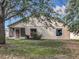 Exterior shot of the house from the backyard featuring a screened-in patio and manicured landscape at 2019 Newtown Rd, Groveland, FL 34736