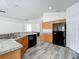 Spacious kitchen with wood cabinets, stainless steel sink, and black appliances at 2019 Newtown Rd, Groveland, FL 34736