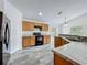 Bright kitchen features stainless steel appliances, wood cabinets, and gray faux wood flooring at 2019 Newtown Rd, Groveland, FL 34736